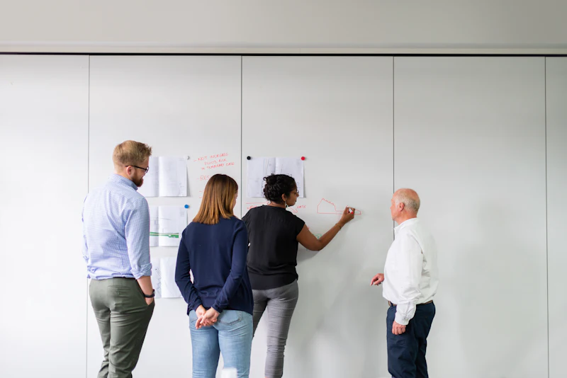 Team mapping out a process plan on a whiteboard